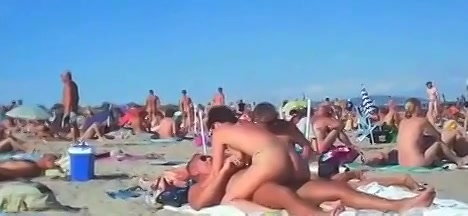 Pijpende en neukende stelletjes worden gefilmd op het naakt strand